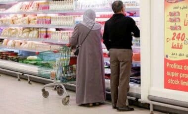 un homme et une femme dans un supermarché pour illustrer l'inflation