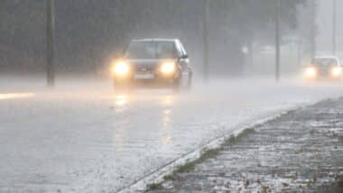 Une voiture sur une route sous une météo pluvieuse