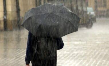 Photo d'une personne tenant un parapluie pour illustrer une météo pluvieuse