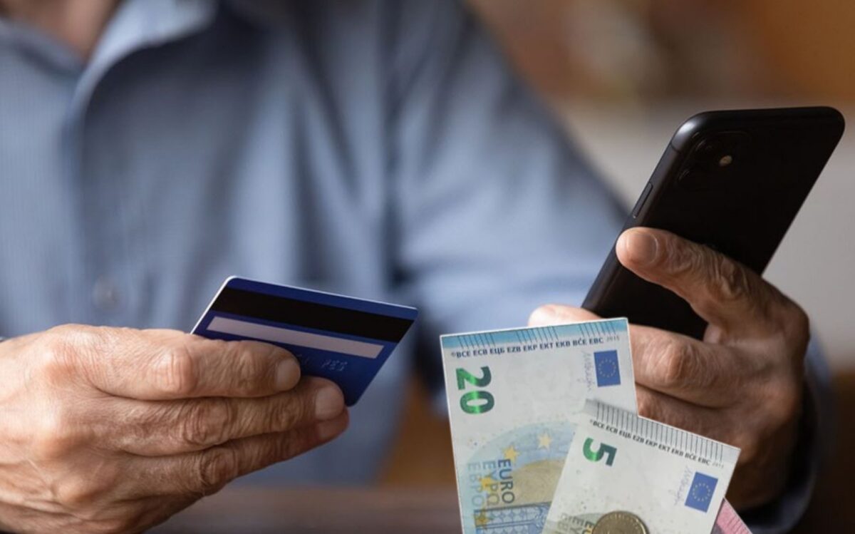 Personne tenant son smartphone et sa carte bancaire