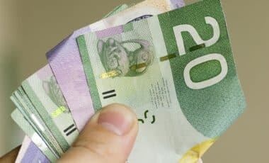 Dollar canadien tennu dans une main