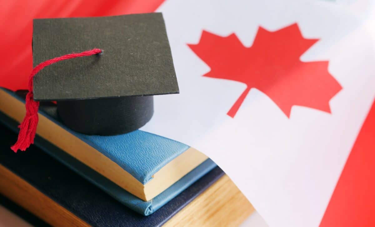 Chapeau de diplômé posé sur des livres et un drapeau du Canada