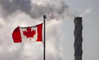 Usine émettant du gaz à côté du drapeau canadien