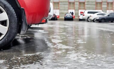 Gel au sol devant une voiture rouge