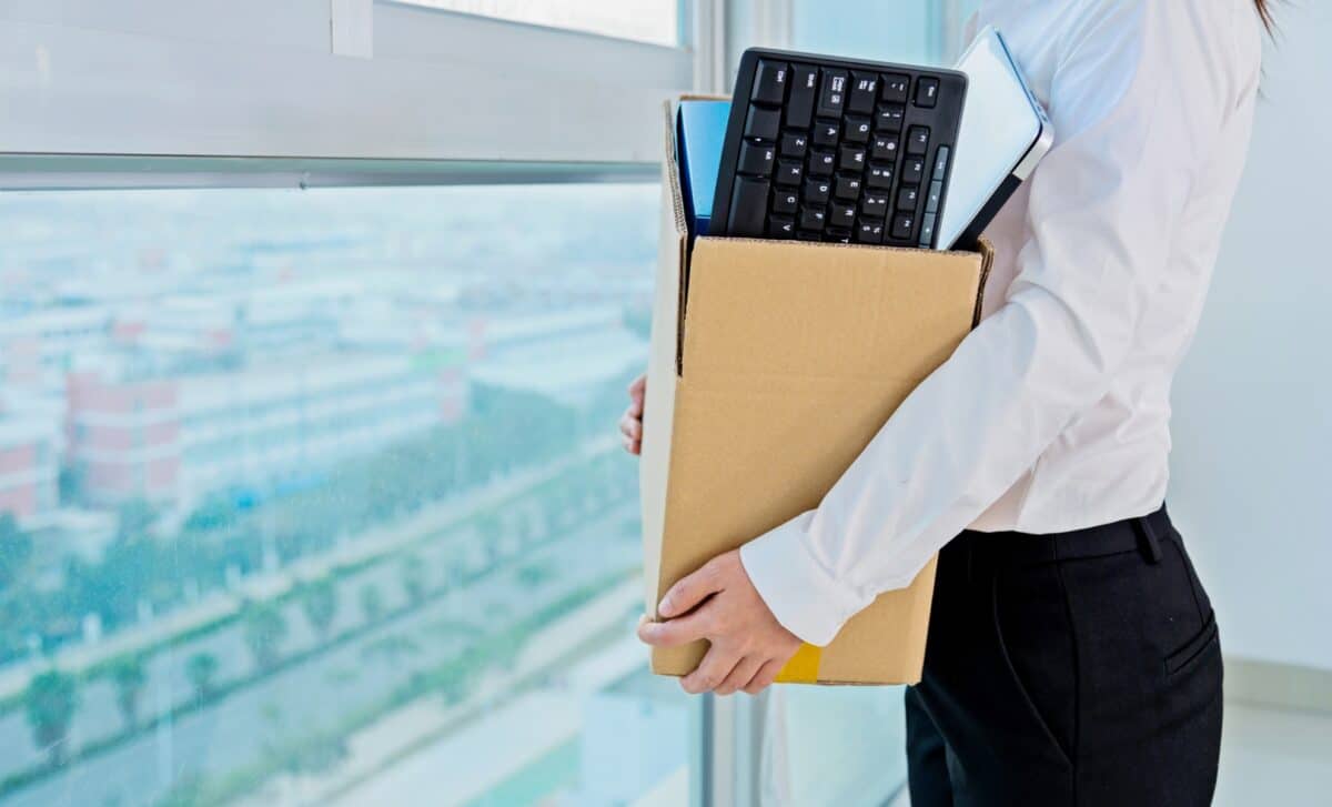 Personne tenant un carton avec l'ensemble de ses effets du bureau