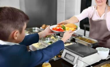 Enfant qui se fait servir à la cantine