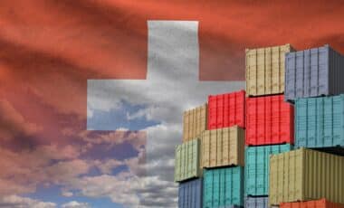 Drapeau suisse et grande pile de conteneurs de fret maritime