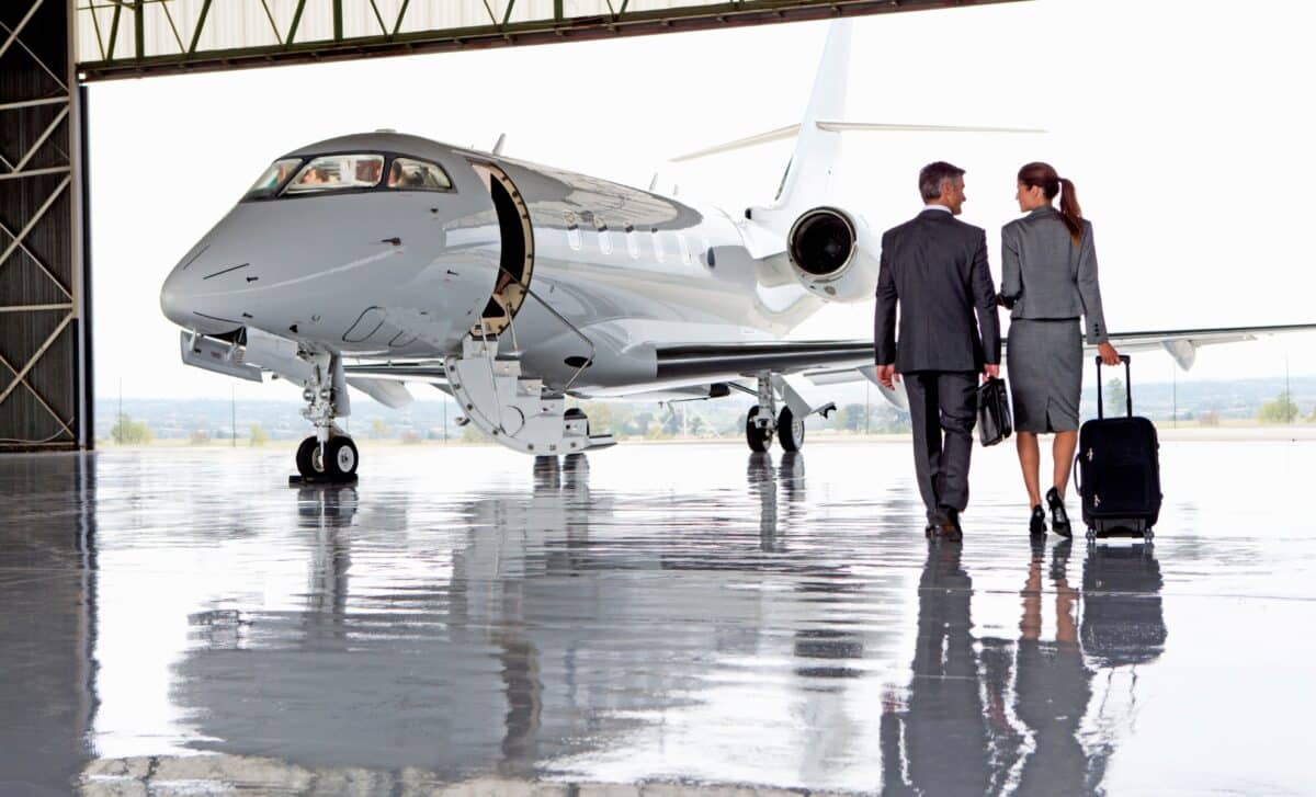 Femme d'affaires et homme d'affaires marchant vers un jet privé