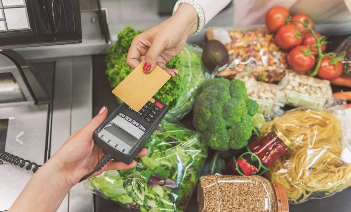 Femme payant avec sa carte de débit au supermarché