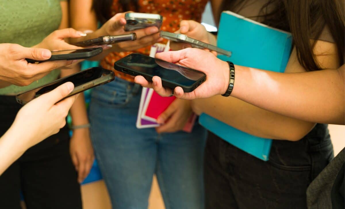 Groupe d'élèves du secondaire utilisant des smartphones