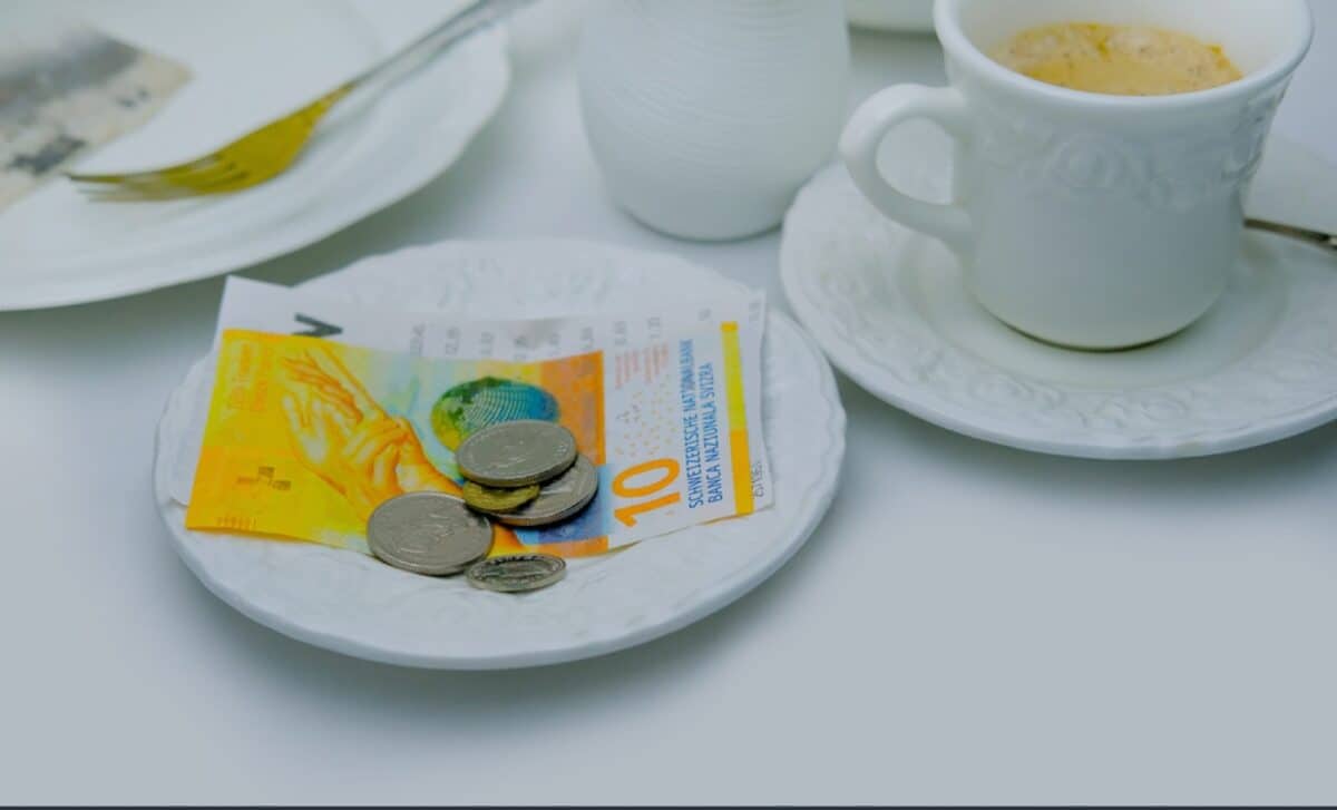 assiette blanche et billets et pièces en francs suisses