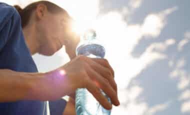 femme buvant de l'eau se rafraîchissant dans la vague de chaleur extrême
