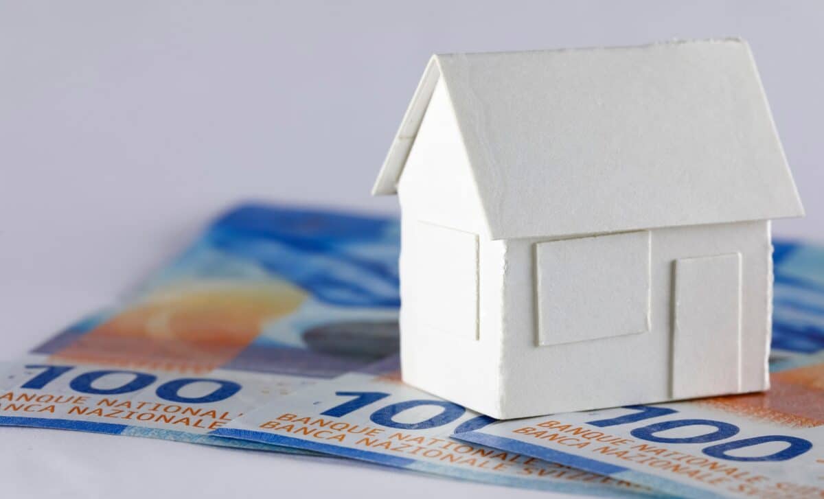 maison en papier blanc sur trois billets en francs suisses