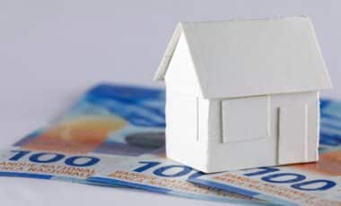 maison en papier blanc sur trois billets en francs suisses