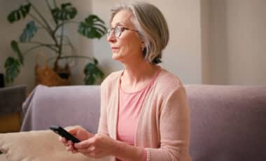 Femme âgée de 60 ans tenant son téléphone