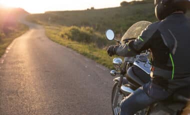 Motocycliste sur la route au coucher du soleil