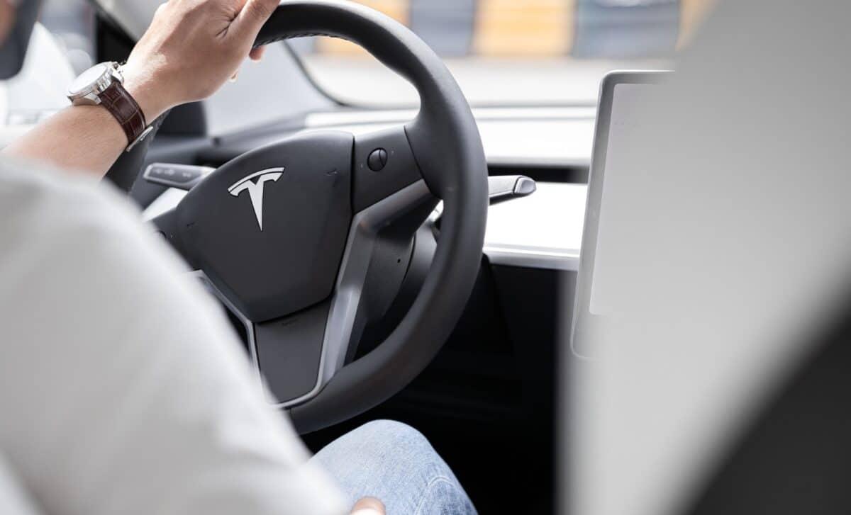Un homme au volant d'une voiture Tesla
