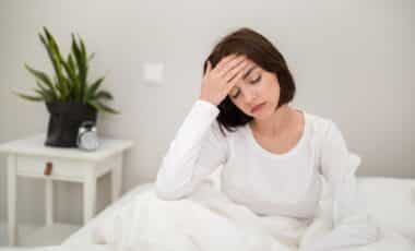 jeune femme se réveillant le matin avec des maux de tête, malade
