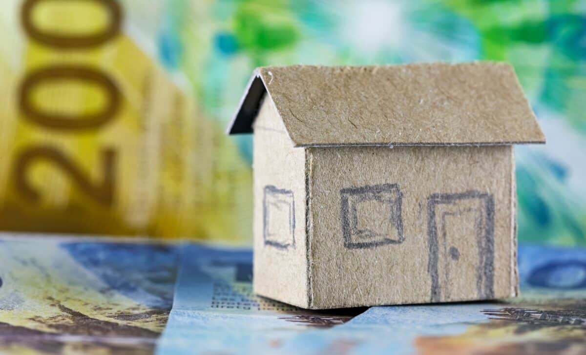 Une maison miniature et des billets de banque suisses