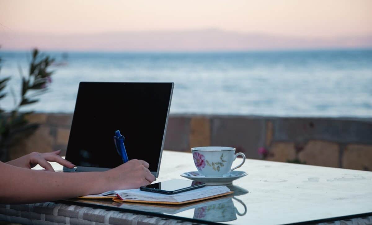 femme travaillant à distance près du bord de mer en vacances