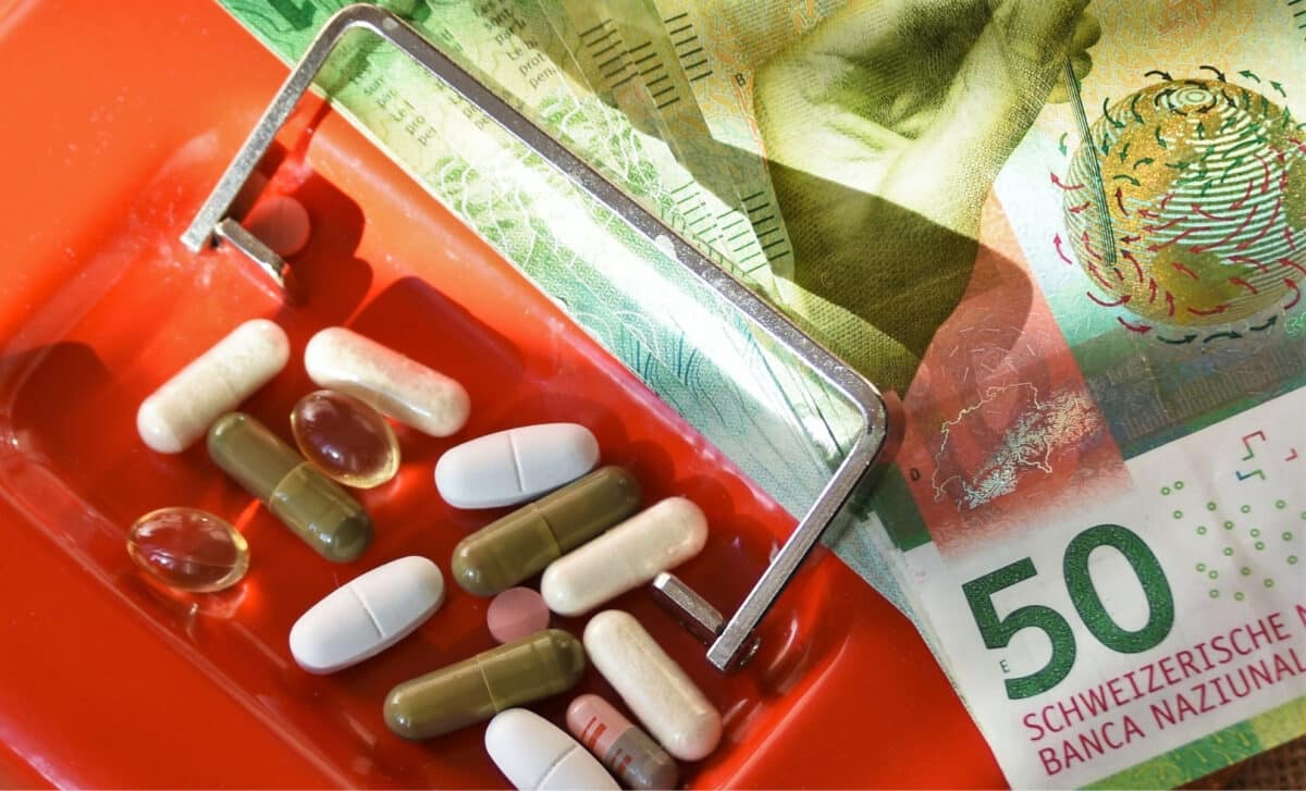 médicaments et billets de francs suisses sur un coffre rouge