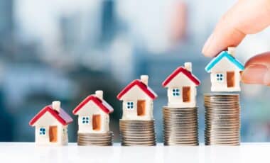 Modèles de maisons au-dessus d'une pile de pièces