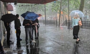 Des personnes marchant avec des parapluies pour illustrer une météo pluvieuse