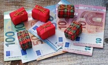 Cadeau de Noël et liasses de billets d'argent pour illustrer la prime de Noël