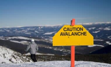 Panneau indiquant une caution avalanche dans une montagne pour illustrer les prévisions météo