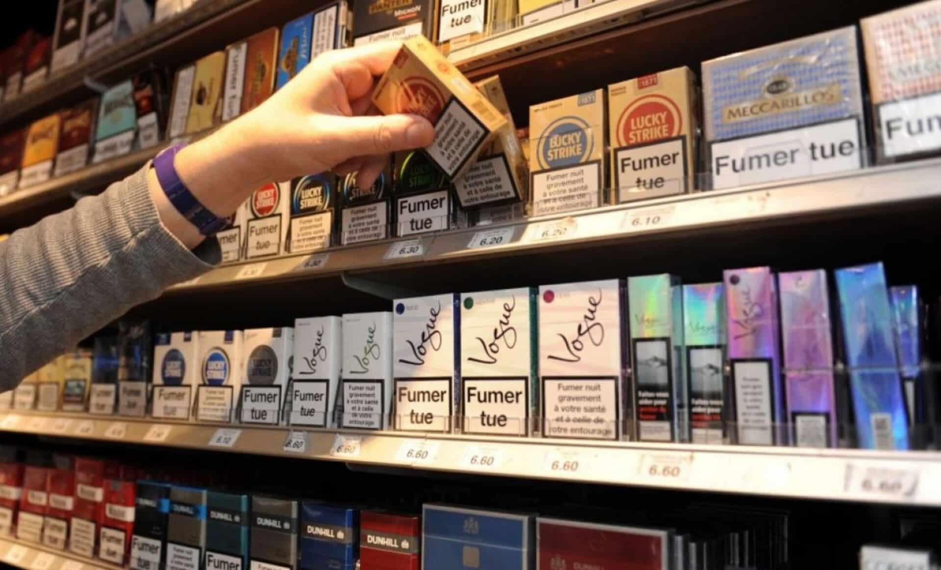 Photo d'une main qui prend un paquet de cigarettes pour illustrer les prix du tabac