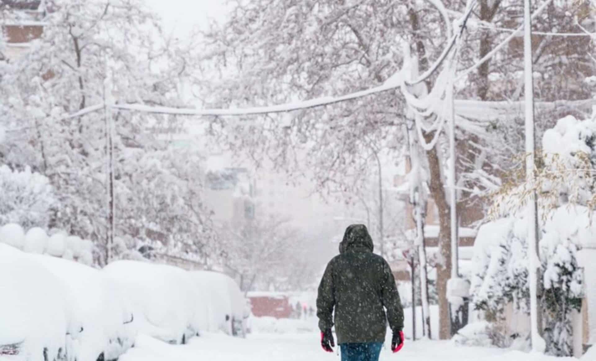 Photo d'un piéton couvert sous la neige pour illustrer les tendances météo de novembre