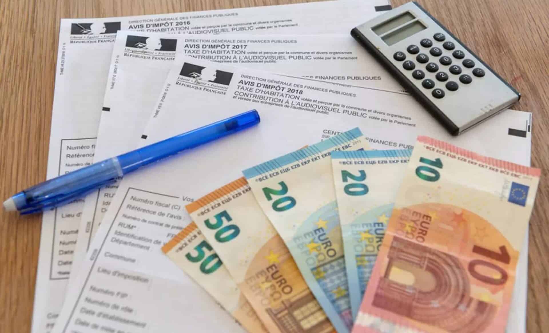 Des déclarations d'impôts, une calculatrice est des billets d'argent pour symboliser la fiscalité