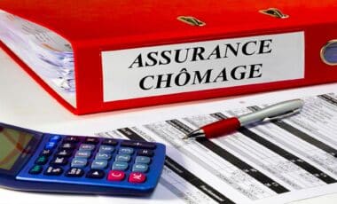 Un dossier nommé « Assurance chômage » avec une calculatrice et un stylo posés sur la table