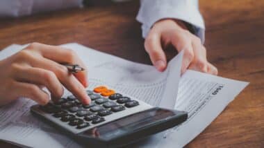 Photo d'un homme qui fait des calculs pour illustrer la hausse des impôts pour certains propriétaires