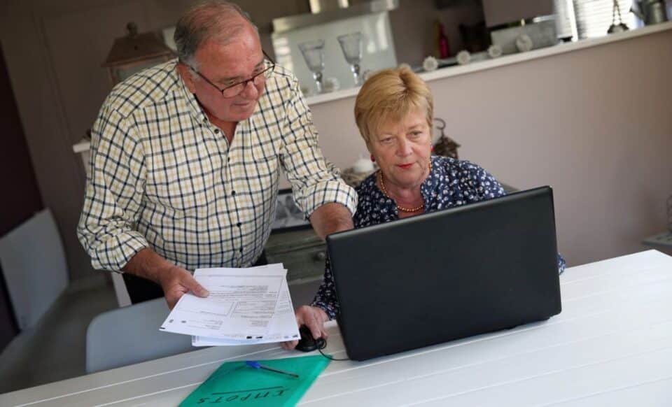 Deux personnes devant un ordinateur pour illustrer la hausse des impôts