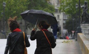 Deux personnes, une avec un parapluie pour illustrer une météo pluvieuse