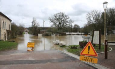 Des panneaux signalant le danger de pluie Inondation sur une route en raison de la météo pluvieuse