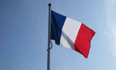 L'image montre un drapeau français flottant sur un fond de ciel bleu, symbole d'union nationale. Associé au mot-clé deuil, ce drapeau évoque une journée de recueillement ou d'hommage national, comme celle décrétée pour Mayotte après une tragédie.