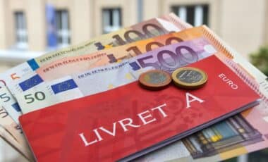 Un livret A placé sur des billets d'argent