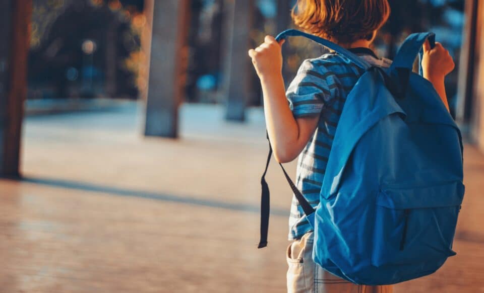 Cette image montre un écolier portant un sac à dos bleu pour illustrer l'allocation de rentrée scolaire