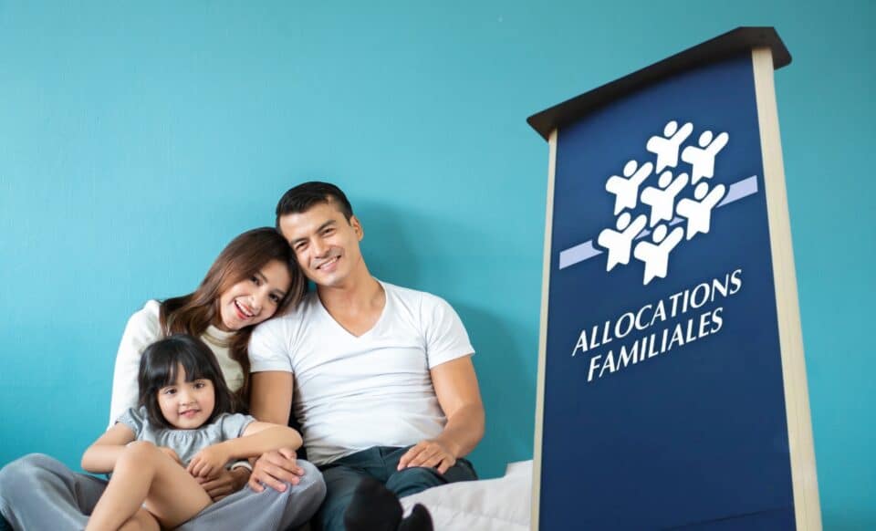 L'image montre une famille souriante composée de deux parents et d’un enfant À droite, un panneau portant l’inscription "Allocations familiales" symbolisant la CAF