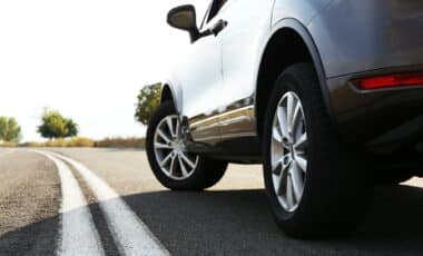 Un automobiliste au volant d'une voiture qui respecte le traçage au sol d'une route