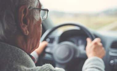 Une personne âgée faisant partie des « seniors » au volant de sa voiture