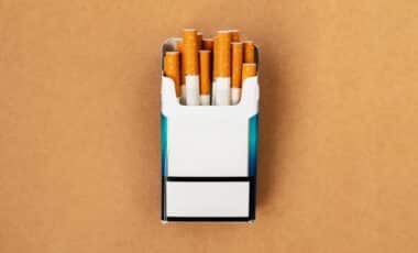 Un paquet de cigarettes ouvert contenant des cigarettes aux filtres visibles pour illustrer la hausse des prix du tabac