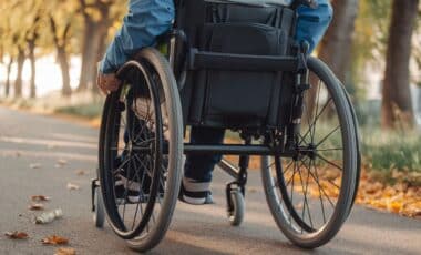 une personne en chaise roulante qui circule sur la route