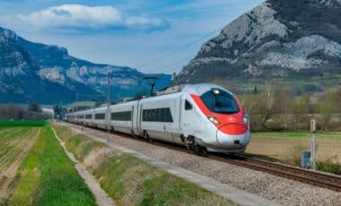 image d'un train de couleur blanche et rouge qui roule au milleu des montagnes pour évoquer la hausse des prix des billets de la SNCF