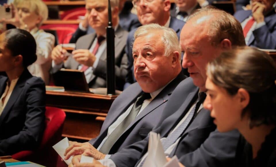 Des sénateurs assis dans l'hémicycle, dont Gérard Larcher au premier plan, reflétant une scène politique officielle au Sénat.