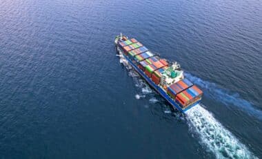 Un cargo transportant des conteneurs en mer, symbolisant le commerce international et le déficit commercial.