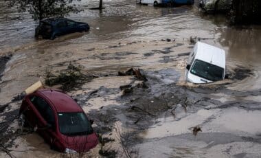 Des véhicules submergés dans une zone inondée illustrent les conséquences des crues liées aux conditions météo extrêmes.