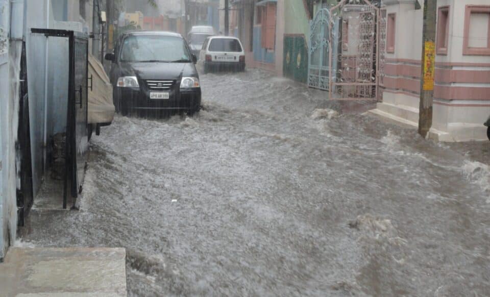 Rue inondée par de fortes pluies, illustrant les effets des crues urbaines liées à la météo extrême.